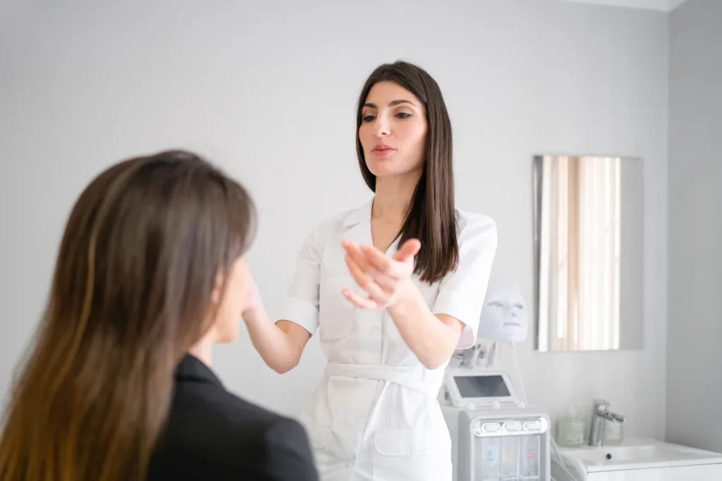 Dermatóloga explicando a una paciente qué es la armonización facial durante una valoración en consulta